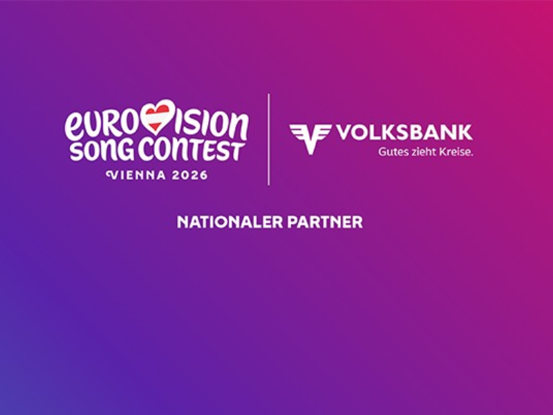 Ein Blau bis Lila-Pinker Farbverlauf im Hintergrund. Darauf befindet sich der Textzug "Eurovision Song Contest Vienna 2026" sowie "Volksbank. Gutes zieht Kreise." und darunter "Nationaler Partner".