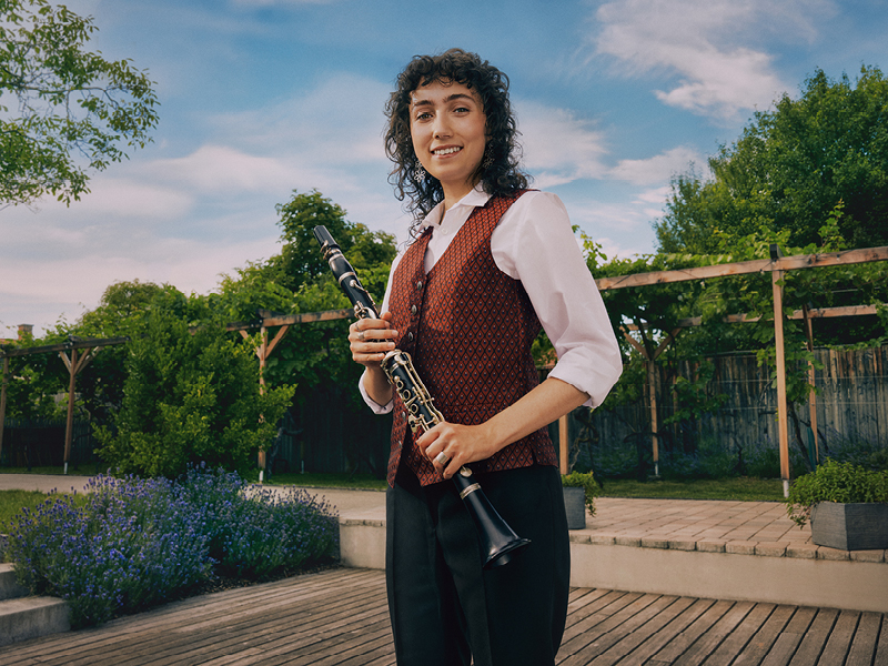 Eine Musikerin mit einer Klarinette in der Hand.