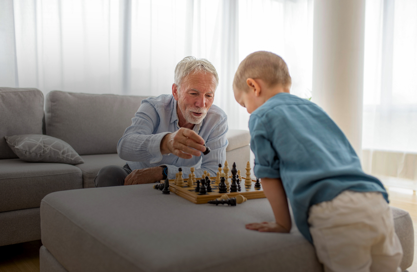 Ein älterer Mann und ein junges Kind spielen Schach.